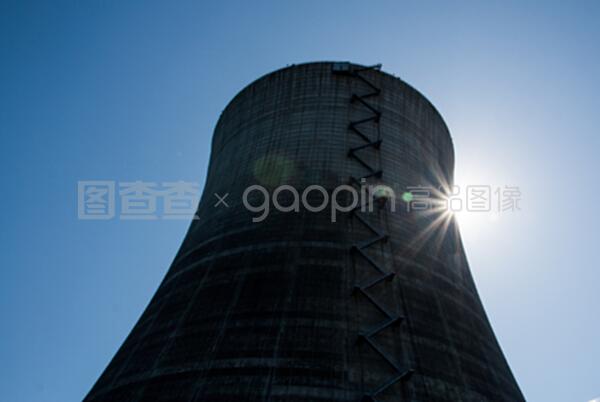 在藍色天空下的核冷卻塔有太陽的爆發(fā)